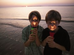 Two boys play with a travel flashlight